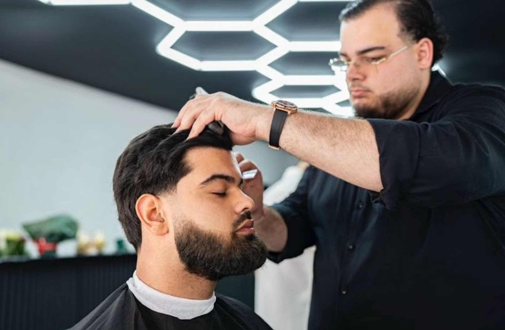 Kapper Tilburg — barbier van Barber's Inc. aan het knippen onder de kenmerkende plafondverlichting